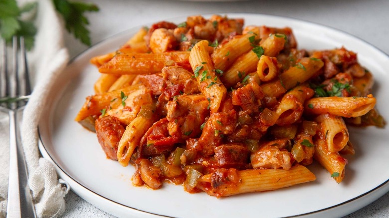 pasta with tomato sauce and parsley on a white plate
