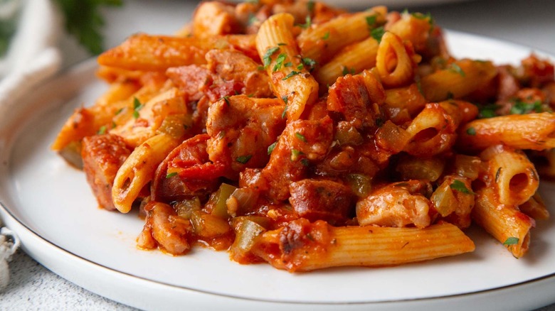 pasta with tomato sauce and parsley on a white plate