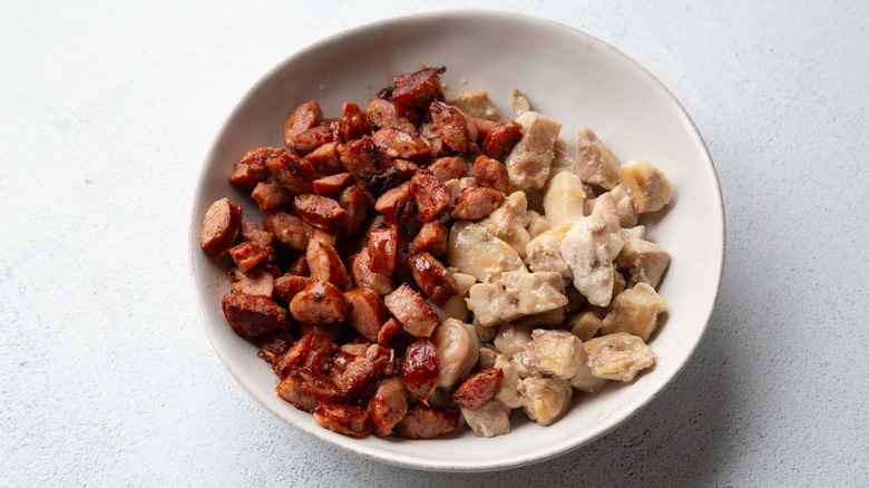 sausage and chicken chunks in a white bowl