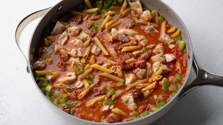 pasta, tomatoes, meat, and vegetables in a pan