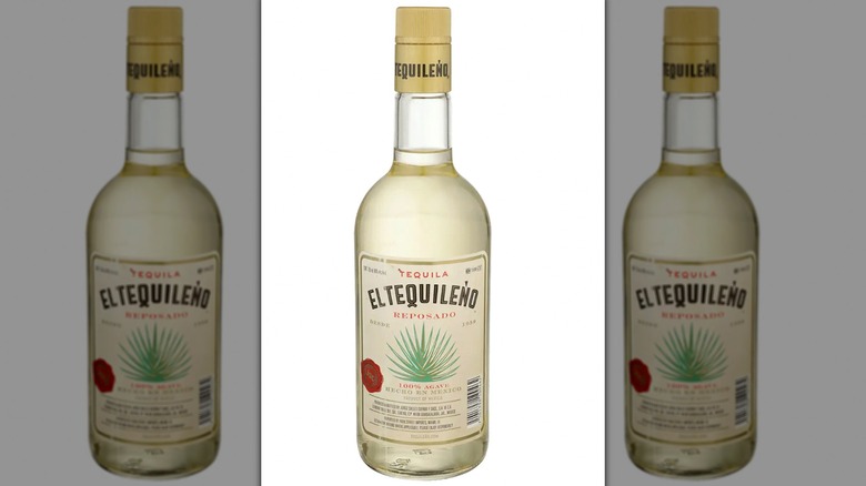 A bartender holding up a bottle of El Tequileño Blanco