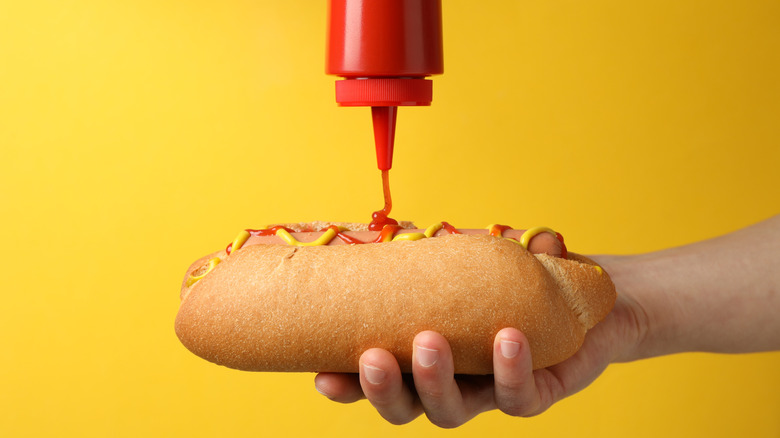 Squirting ketchup on hot dog