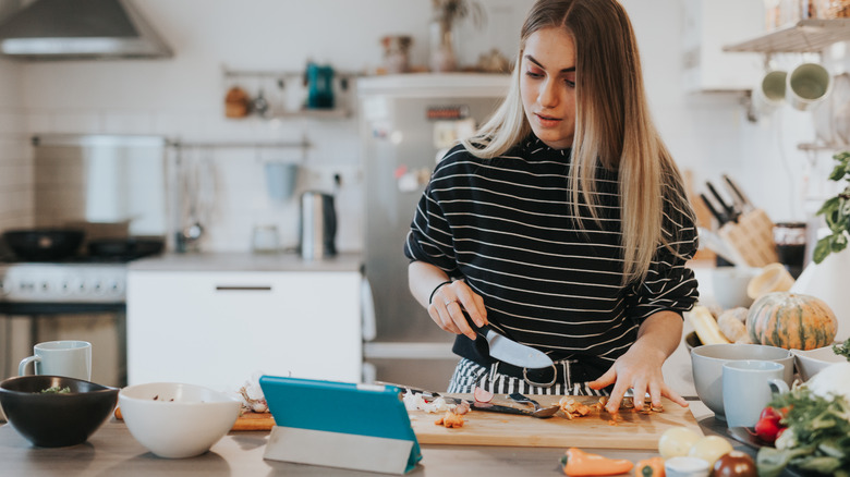 woman cooking looking at iPad