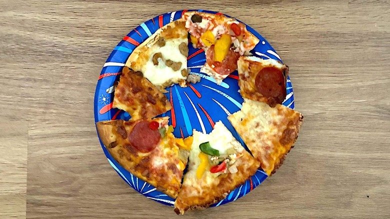 Red, white, and blue-themed paper plate with partly eaten pizza slices on it