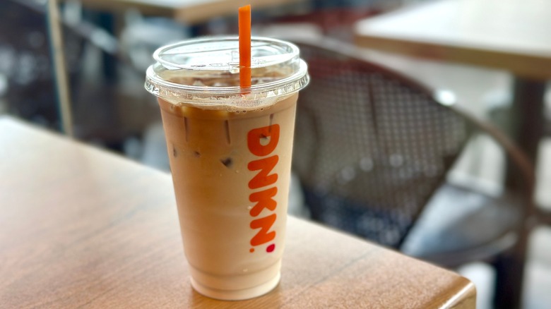 A Dunkin' iced coffee on a wooden table