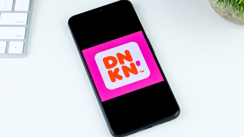 The Dunkin' app on a phone on a white desk