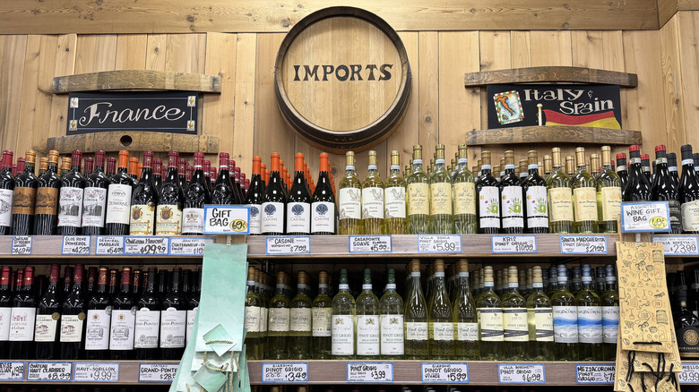 The wine aisle at Trader Joe's, with a decorative barrel reading IMPORTS in Trader Joe's font
