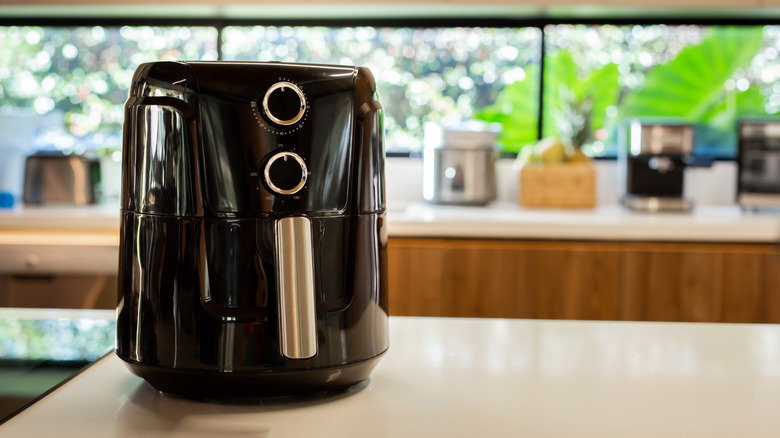 Modern black air fryer sitting on kitchen countertop