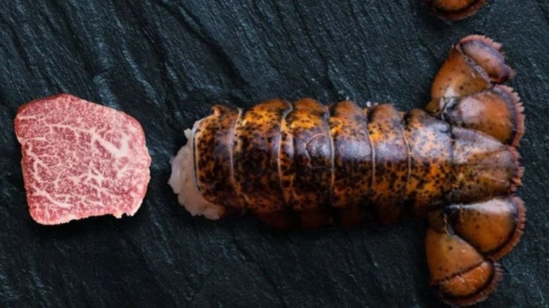 A cooked steak and lobster together