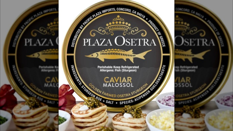 A jar of caviar on ice with to lemon slices