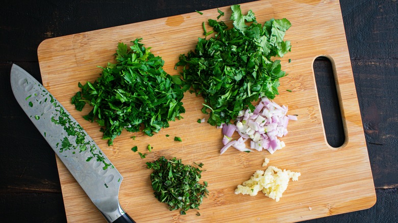herbs and alliums on cutting board