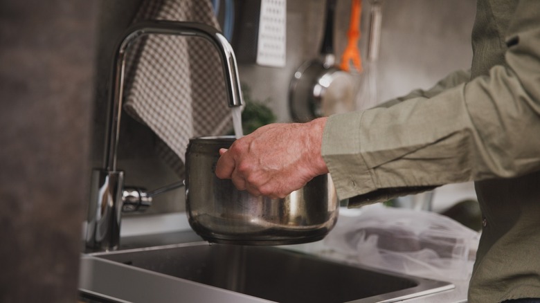 man filling pot with water