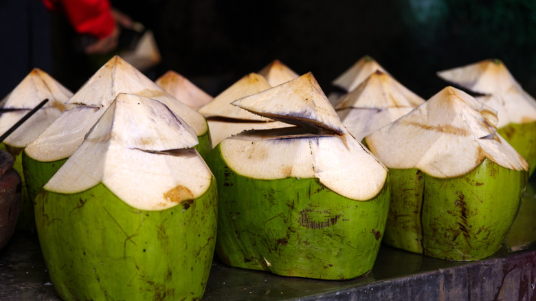 Fresh green coconuts cut open and ready to enjoy at a filipino food market