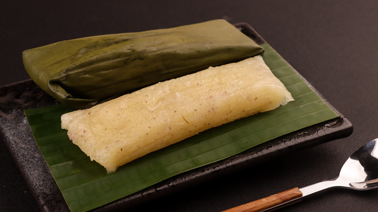Filipino cassava suman unwrapped on banana leaves.