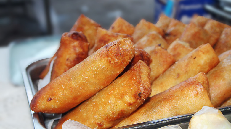 A platter of golden brown turon for sale at a market