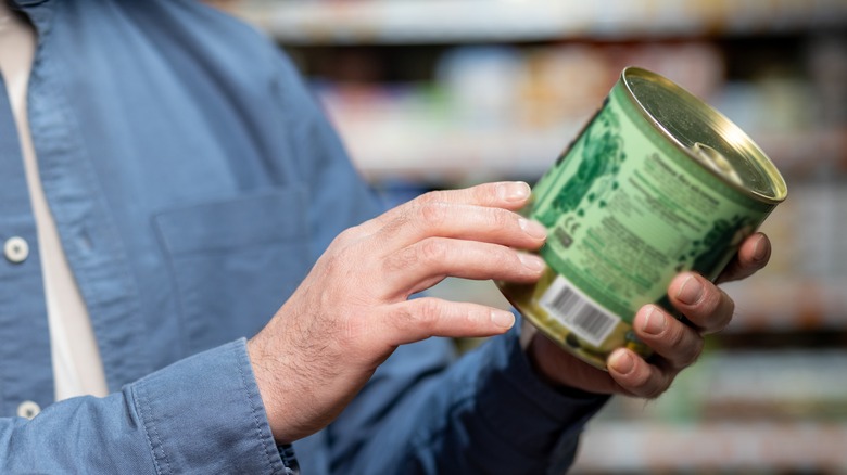 Close up of a man reading the label on a can