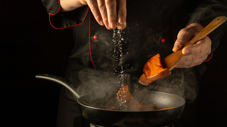 A chef adding some MSG to food