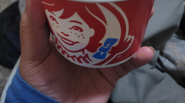 Closeup of cheese sauce in a red Wendy's cup.