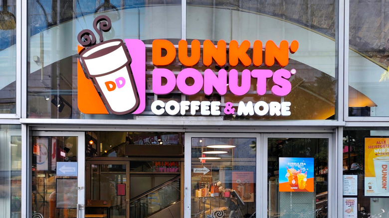 The exterior of a Dunkin' Donuts, featuring the logo above the entrance.