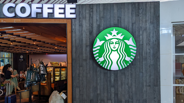 Exterior picture of a Starbucks with a logo next to the entrance.