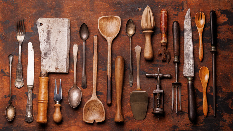 A selection of vintage kitchen tools on an aged wooden tabletop