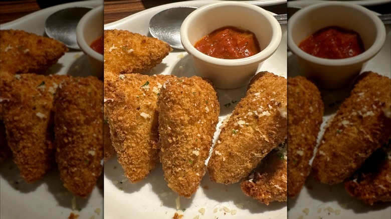 A deep-fried Olive Garden appetizer, served with a marinara sauce