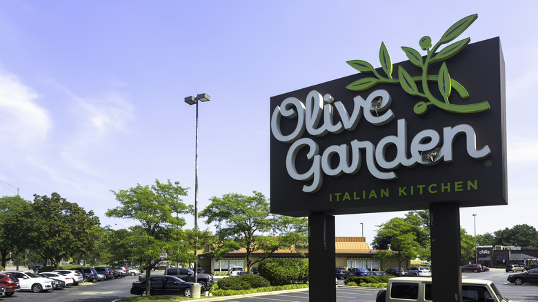 An Olive Garden sign outside a restaurant parking lot