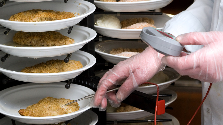 chef checking the temperature of the food