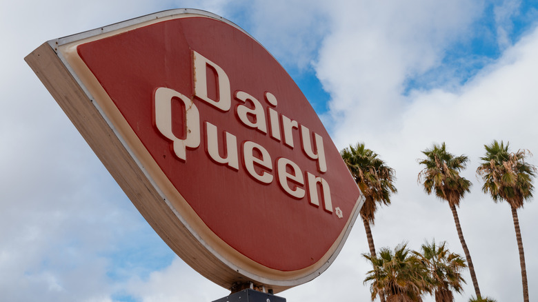 A Dairy Queen sign in front of palm trees