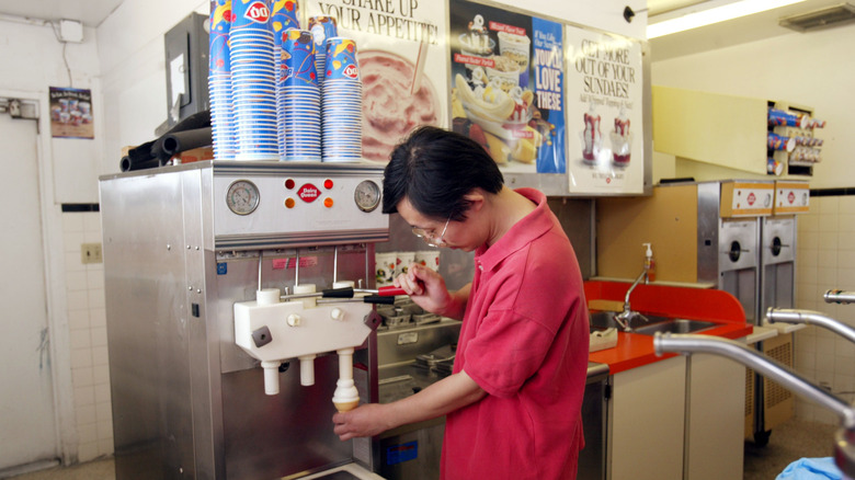 A man operates a DQ soft serve machine