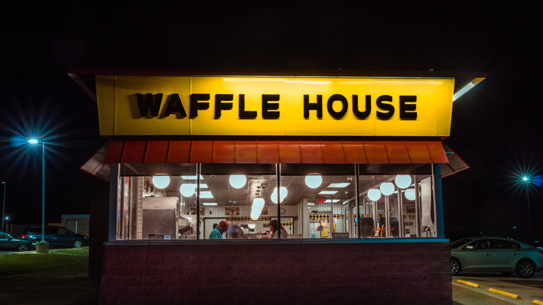 An exterior view of a well-lit Waffle House at night.