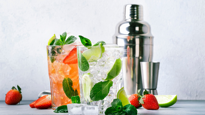 Two cocktails alongside a shaker
