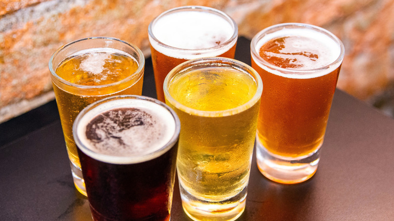 five glasses of different beers in a range of colors