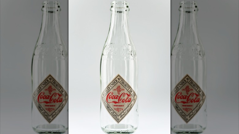 Empty 1906 Coca-Cola bottle with straight sides and a diamond label.