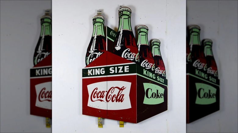 Vintage store sign in the shape of a 6-Pack of Coca-Cola bottles labelled King Size.