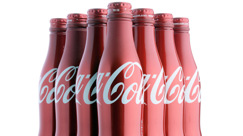 Aluminium Coca-Cola bottles in their characteristic red color.