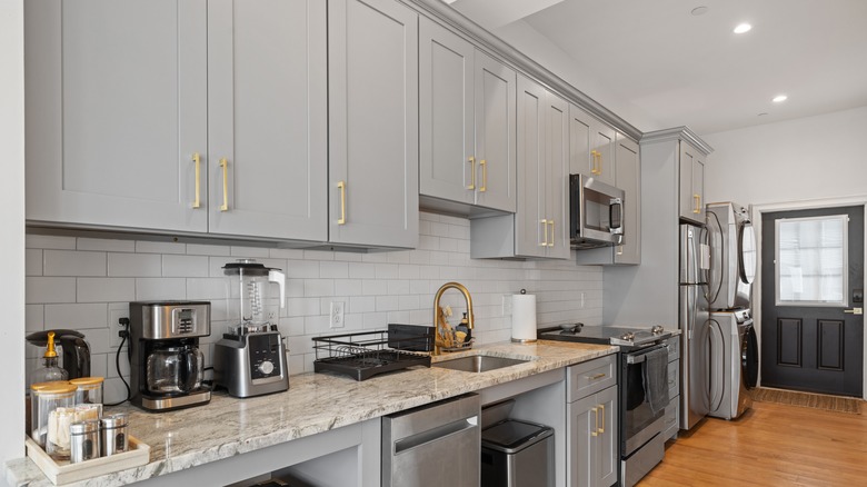 Light gray kitchen cabinets with gold handles