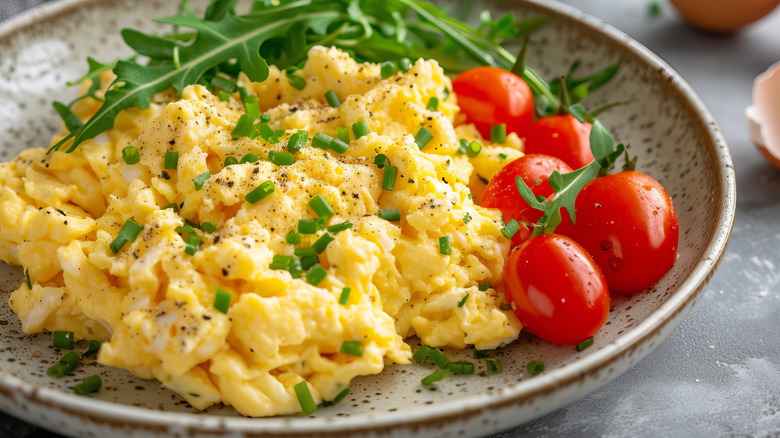 Plate of scrambled eggs with tomato & chive
