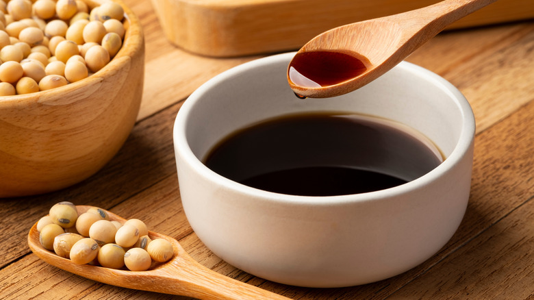 Cup of soy sauce with spoon and soy beans