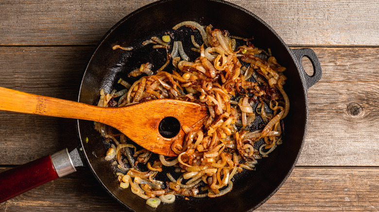 Caramelized onions in pan with wooden spoon