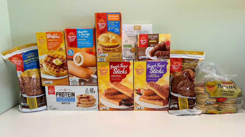 A large group of Aldi's frozen breakfast items on a counter with a green background