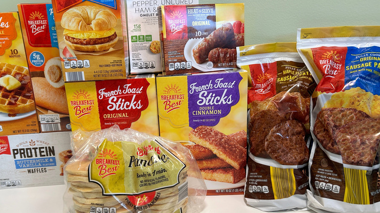 A large group of Aldi's frozen breakfast items on a counter with a green background