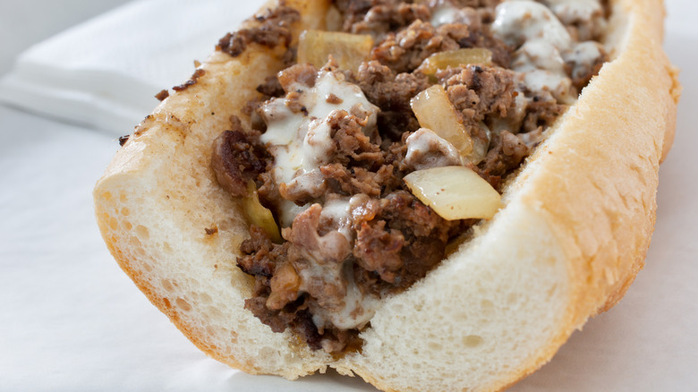 A cheesesteak with melted white American cheese and onions