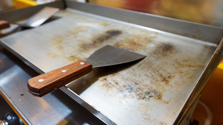 A clean grill with a spatula laying on top