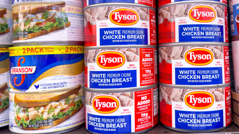 Cans of chicken on a shelf in the grocery store