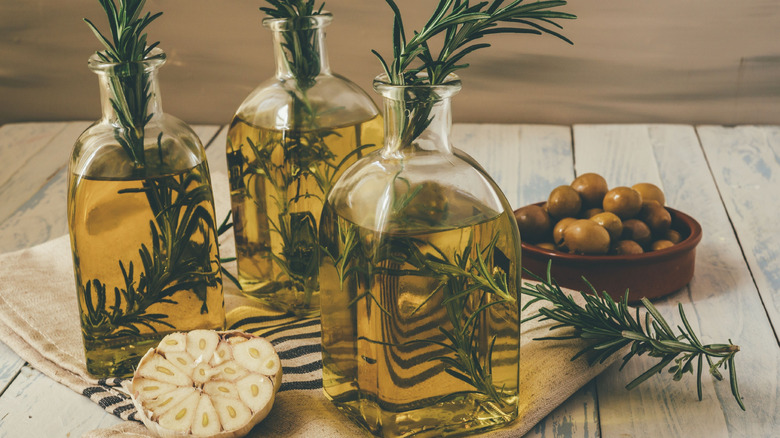 Jars of olive oil infused with fresh rosemary sprigs