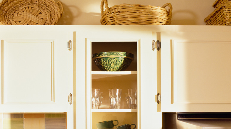 Close-up on baskets stored above kitchen cabinet