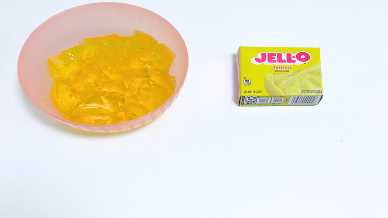 A bowl of gelatin next to a packet of Jell-O Lemon