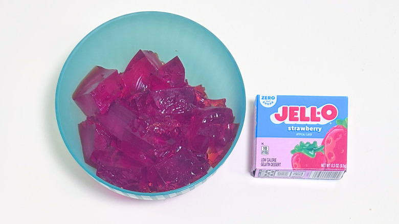 A bowl of gelatin next to a packet of Jell-O Zero Sugar Strawberry