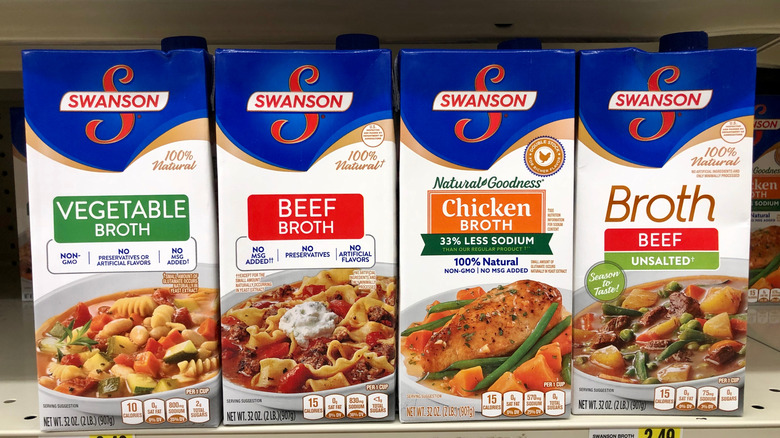 Boxes of vegetable, beef, chicken, and unsalted beef broth in a line at the grocery store